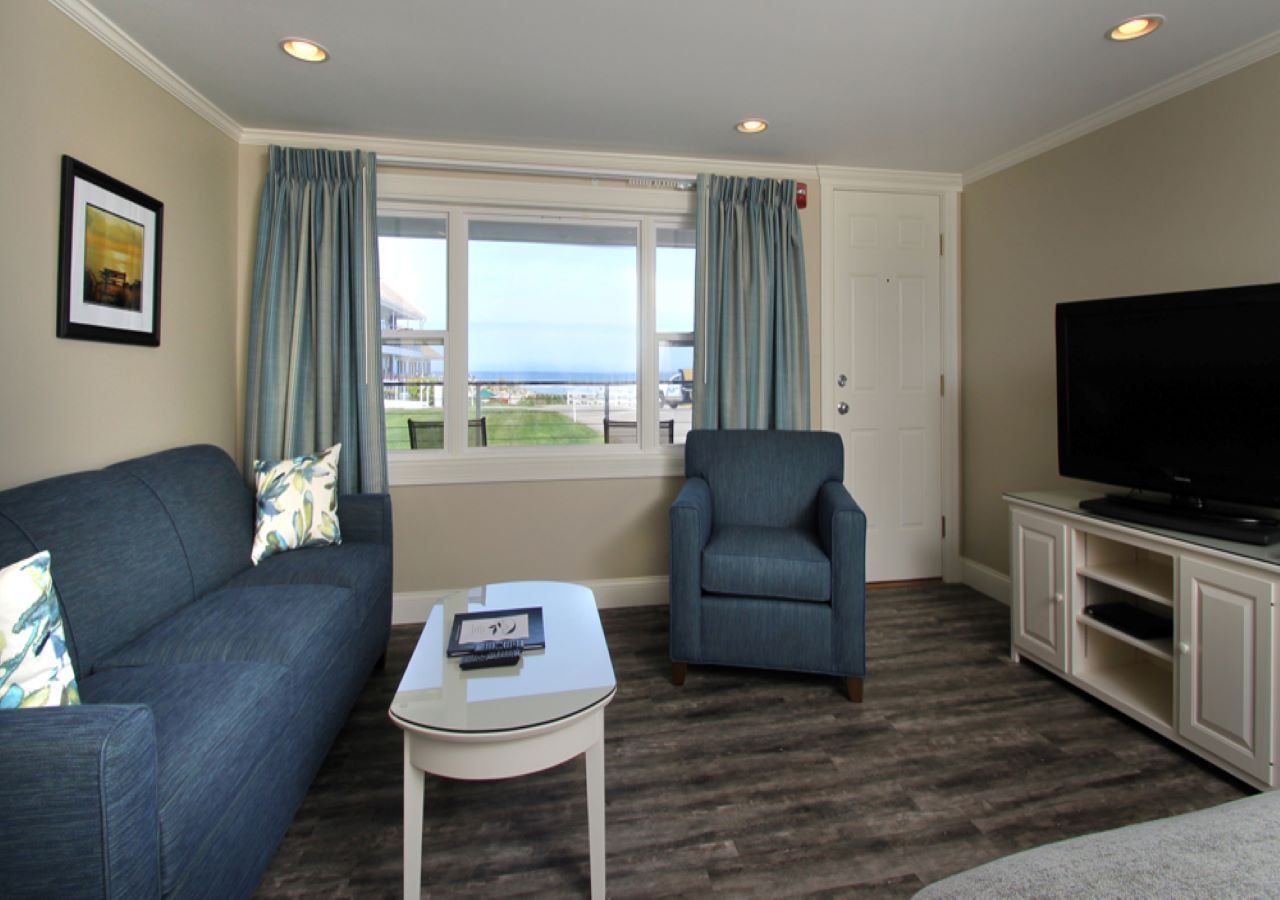 Coffee table and flat screen TV in seating area with ocean view.