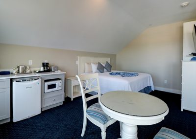 View from sliding door toward the dining area, king bed, second TV and closet.