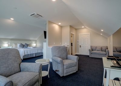 TV and recliner area, king bed, desk, bathroom door, entrance door and loveseat.