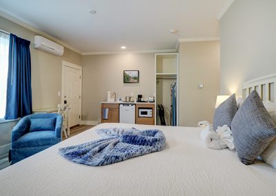 View from Room 73's interior corner, showing king bed, seating area, wet bar, closet and entrance door.