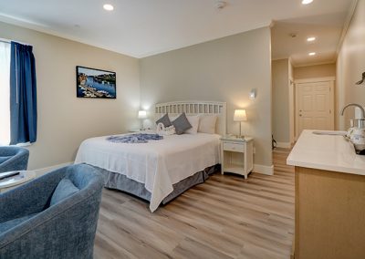 View from Room 74's entrance door, showing seating and bed areas, and hallway to bathroom, second bedroom, and optional adjoining door with Room 73.