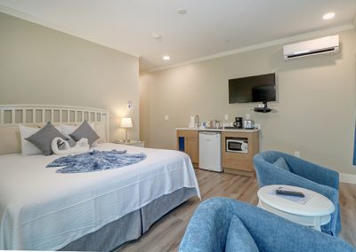 View of Room 74 from interior corner toward seating area, bed and wet bar.