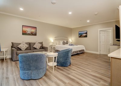 View of Room 75 from the entrance door, showing the large seating area, king bed, and door to the bathroom.