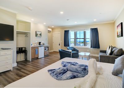 Room 75, view from the interior wall showing the king bed, large seating area and ocean view.