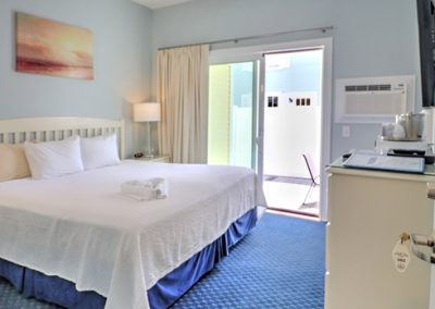 King bed with ceiling fan and sliding door to patio.